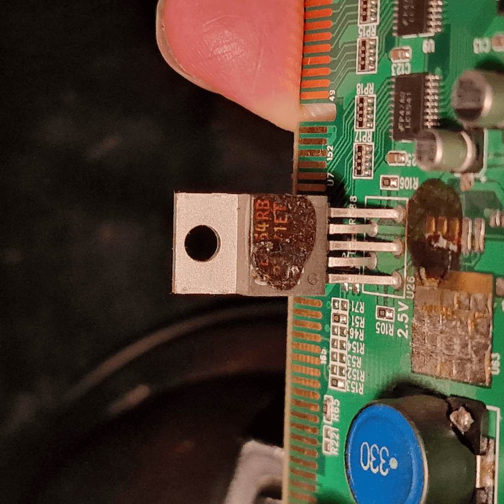 Burnt transistor on a circuit board indicating component failure and the need for professional repair